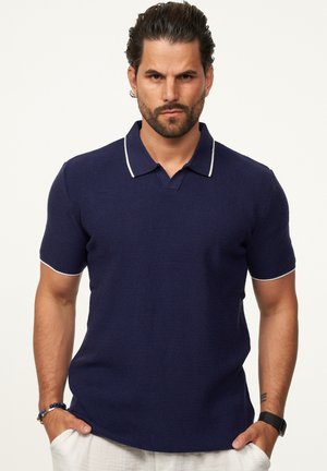 Navy-blaues Poloshirt aus strukturiertem Stoff, mit weißem Kragen und Ärmelsaum, Kurzärmeln und klassischem Schnitt.