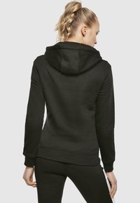 Black hooded sweatshirt with ribbed cuffs and hem, featuring a smooth texture and adjustable drawstring on the hood.