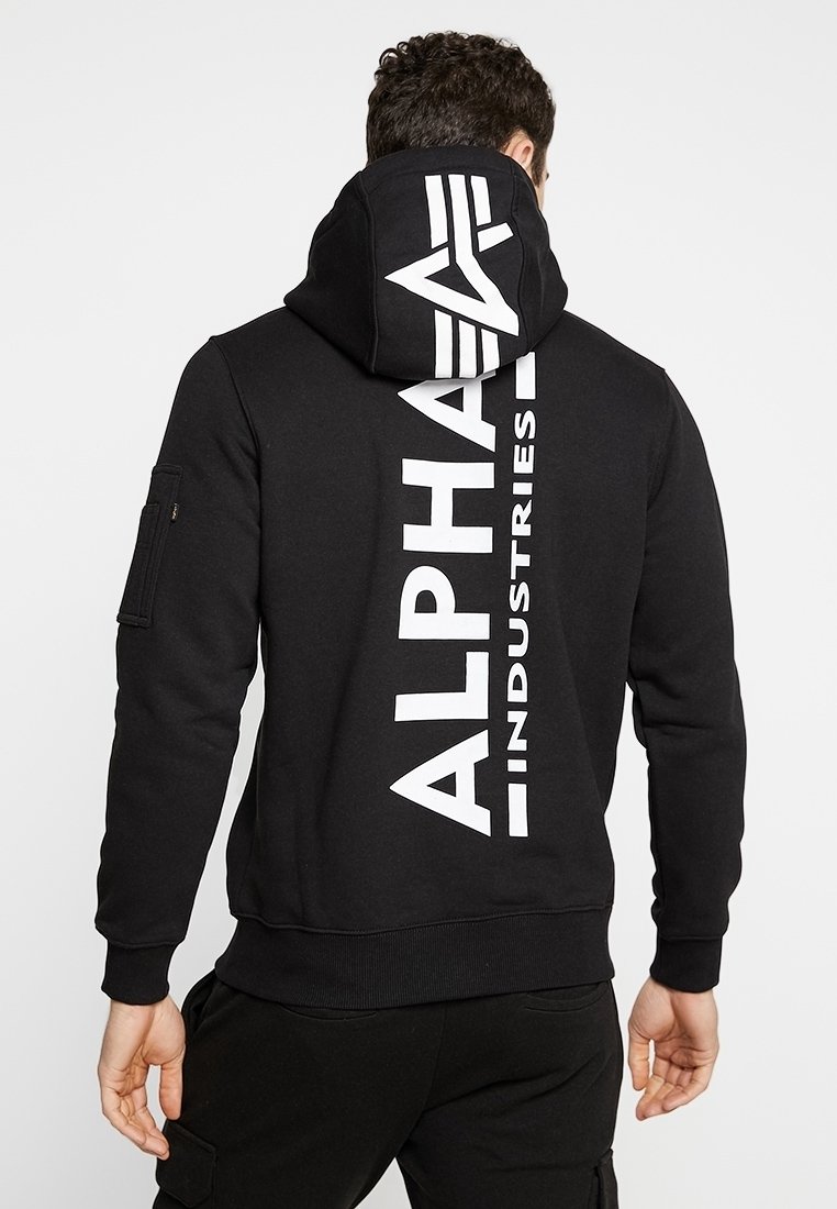 Sweat à capuche noir avec un grand logo blanc "ALPHA INDUSTRIES" imprimé verticalement au dos. Il dispose d'une capuche avec cordon de serrage et de poignets côtelés.