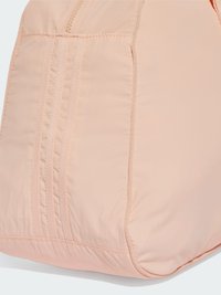 Peach-colored backpack with a smooth, textured surface, features a zipper, and vertical stitched accents on the side.