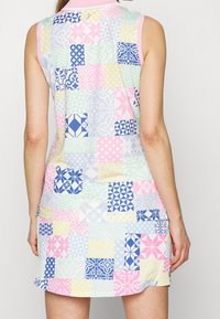 Ärmlös klänning med ett lapptäcksdesign som har pastellfärger, geometriska mönster och en rosa krage. Lätt och stretchigt material.