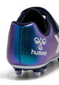 Chaussure de football Hummel avec une tige synthétique irisée violet et bleu, logo blanc, et une finition texturée avec des crampons moulés en caoutchouc.
