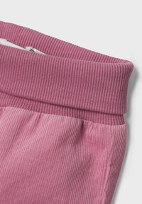 Rosa kordväv med räfflad textur, som har en bred, strukturerad midja och en slät, ljusare rosa sektion nedanför.