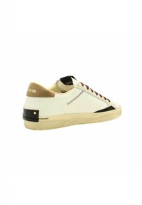 Baskets basses en cuir blanc cassé avec des accents en daim marron. Possède des lacets marron, un détail au talon noir et une semelle texturée.