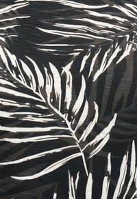 Μαύρο ύφασμα με λευκά και γκρι αφηρημένα μοτίβα φύλλων φοίνικα που δημιουργούν ένα τολμηρό τροπικό σχέδιο.