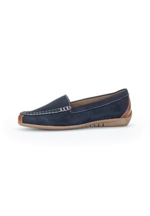 Mocassins en daim bleu marine avec des accents de talon brun contrastants. Présente des détails de couture et une semelle en caoutchouc flexible pour le confort.