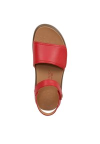 Red leather sandal with two wide straps. Cushioned insole in tan color. Rounded toe and ankle strap feature a decorative button. Flat heel.