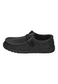 Scarpe slip-on nere con tomaia in tessuto texturizzato, dotate di suola in gomma, cuciture minime e un accento decorativo in pizzo.
