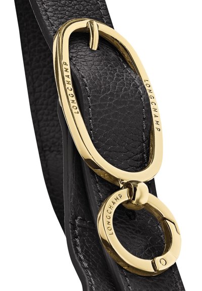 Schwarzes strukturiertes Lederarmband mit zwei miteinander verbundenen polierten goldfarbenen Metallringen, die mit dem Markennamen "LONGCHAMP" graviert sind.
