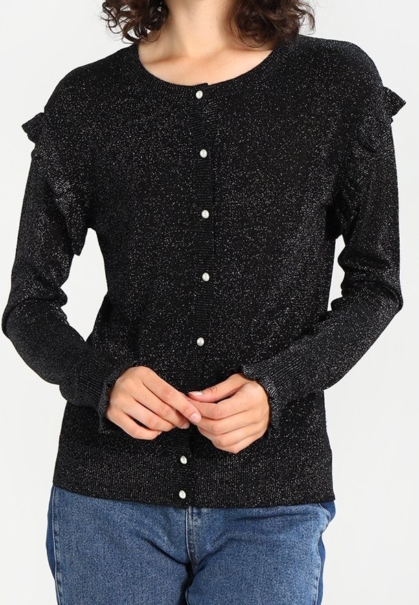 Svart knapp-up kofta med glittrande textur, volanger vid axlarna och pärlknappar. Bärs över en ljusblå denimunderdel.