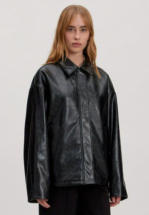 Zwarte faux leren jack met een kraagontwerp, oversized pasvorm en zichtbare naaddetails. Heeft zijzakken en een soepele textuur.
