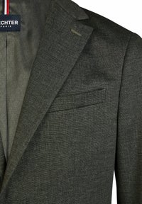Dunkelgrauer Blazer mit strukturiertem Stoff, mit Kerbkragen und einer Brusttasche. Innenfutter mit gemustertem Design und dem Markennamen.