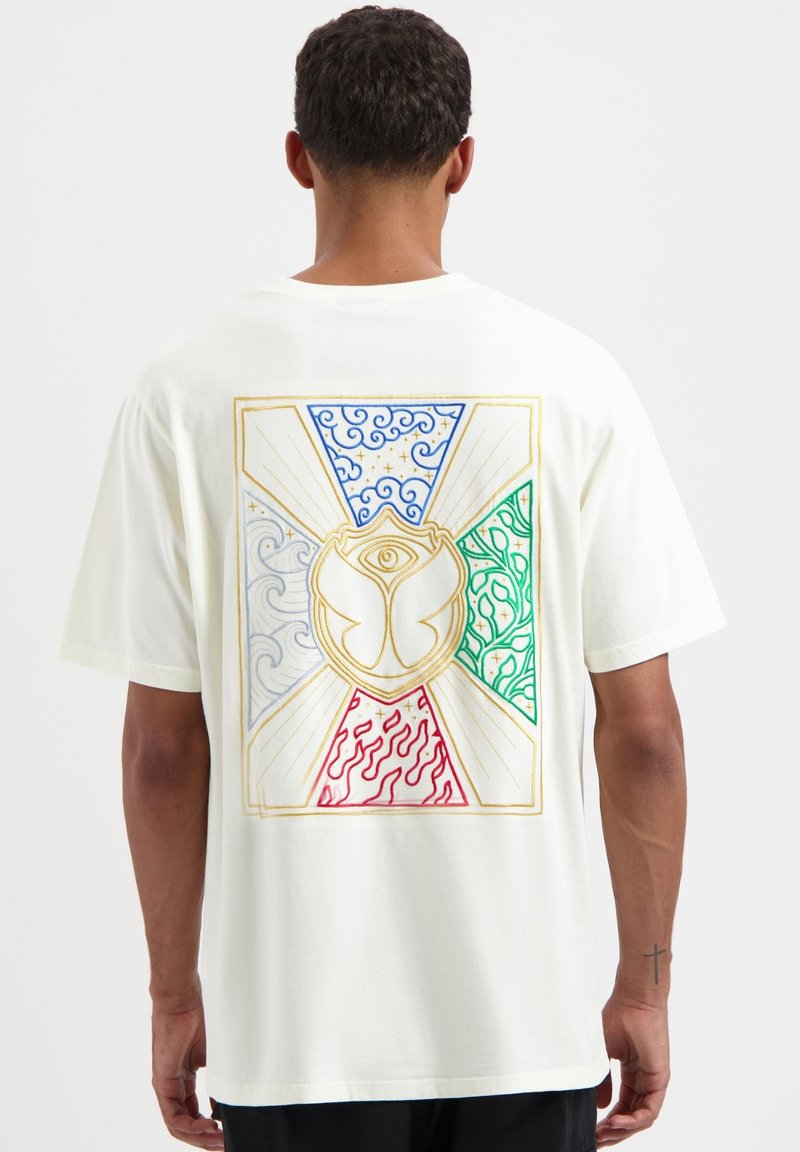 Crème T-shirt met korte mouwen met een kleurrafieke afbeelding op de achterkant. Het ontwerp omvat blauwe golven, groene en rode patronen, en een centraal embleem.