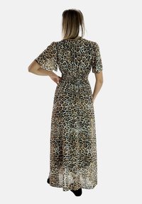 Robe maxi en imprimé léopard avec des manches courtes bouffantes, taille cintrée et matériau léger. Présente un design fluide et transparent, longue jusqu'aux chevilles.