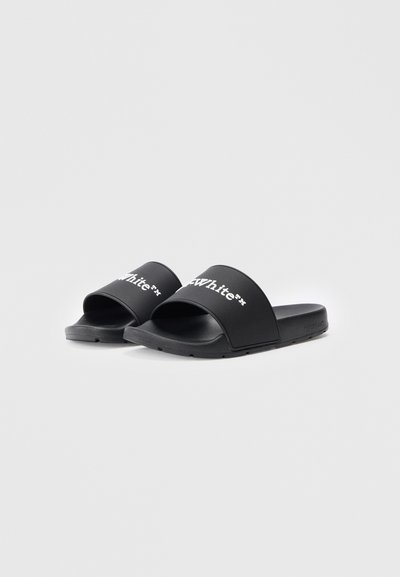 Sandale negre tip slip-on, fabricate din cauciuc neted, cu o bandă lată ce prezintă un text alb cu logo-ul, talpa plată și fără modele sau accente vizibile.