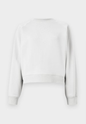 Bluza simplă albă cu mâneci lungi și guler rotund, cu manșete și tiv striate, văzută din spate pe un fundal alb.