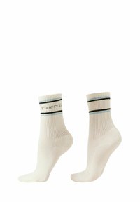 Ein Paar weiße gerippte Crew-Socken mit schwarzen und blauen Streifen nahe der Oberkante und teilweise sichtbarem schwarzen Text auf einer Socke.