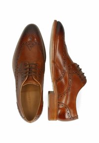 Scarpe brogue in pelle marrone con dettagli perforati, punta rotonda e tacco medio. Presentano un classico design con lacci e accenti decorativi.
