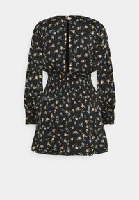 Svart klänning med långa ärmar och insvängd midja. Har ett blommönster i rosa och blått, med en nyckelhålsdetalj på baksidan och texturerad tyg.