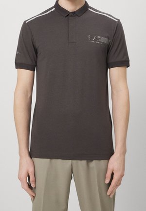 Polo gris foncé avec col à revers, patte à deux boutons et rayures blanches sur les épaules. Présente un logo brodé sur la poitrine.