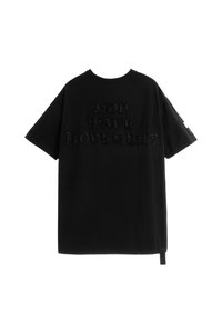 Camiseta de algodón negra con letras gruesas y texturizadas que dicen "MOVIMIENTO MOD WAVE". Mangas cortas, corte holgado, detalle en la costura lateral.