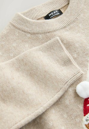 Beige kötött pulóver, texturált felülettel, bordázott nyakkal és mandzsettával, díszes pom-pom-mal és hímzett részletekkel.