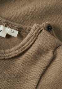 Brązowy sweter dzianinowy z okrągłym dekoltem i zapięciem na napy, charakteryzujący się miękką fakturą i małą metką wskazującą rozmiar oraz markę.