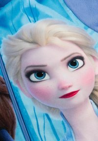 Coperta con personaggio che presenta un primo piano di un personaggio femminile con capelli biondi, occhi azzurri, pelle chiara e labbra rosse su uno sfondo blu.