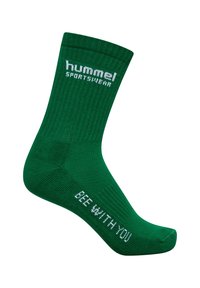 Grön strumpa som når mitt på vaden, tillverkad av ribbat material. Har "hummel SPORTSWEAR"-logotypen i vitt på vaden och "BEE WITH YOU" tryckt på foten.
