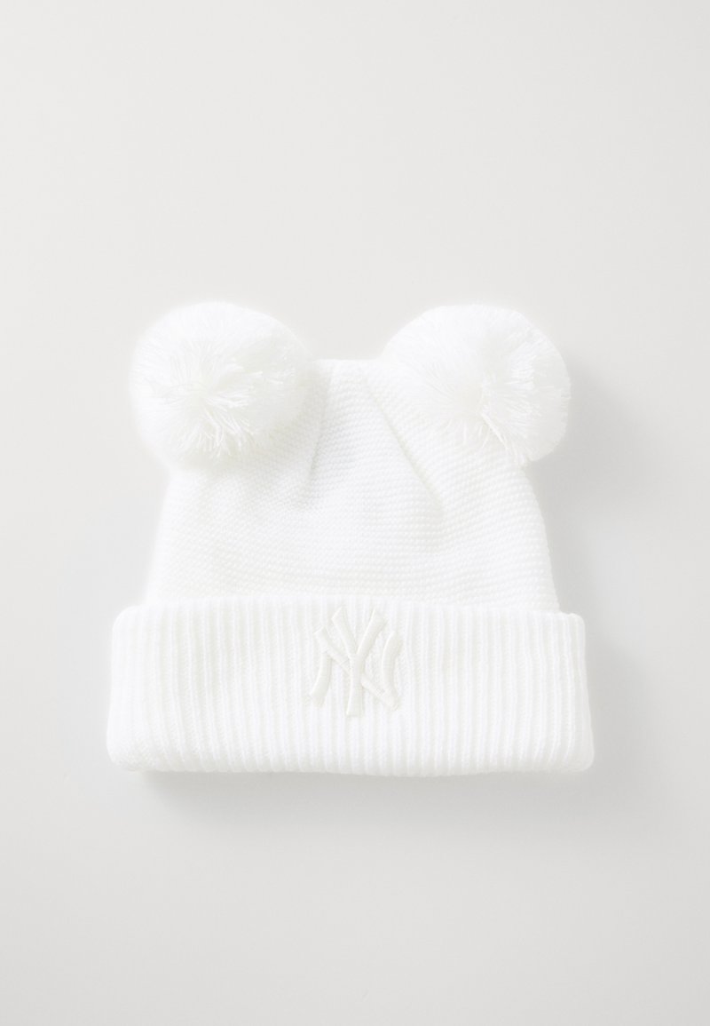 Bijela pletena kapa s dvije pom-pom punđice na vrhu i rebrastim rubom, s izvezenim logotipom sprijeda. Tekstura materijala.