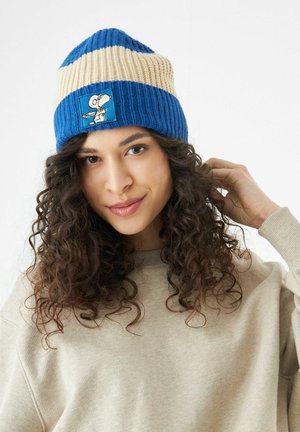 Bonnet en tricot avec des rayures bleu et crème, présentant une patch de Snoopy. Sa texture est côtelée, offrant élasticité et chaleur.