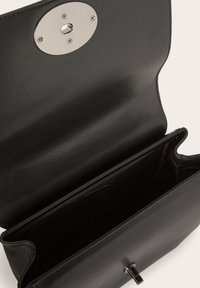 Borsa a tracolla nera in pelle con una chiusura ovale in argento lucido, aperta per rivelare un ampio interno con una superficie liscia e senza compartimenti visibili.