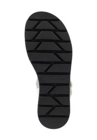 Black rubber shoe sole with textured grip pattern, featuring grooves and branding detail. Lightweight and designed for traction.