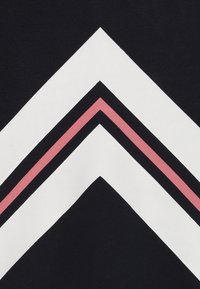 Tres franjas en forma de Chevron apuntando hacia arriba: dos franjas blancas anchas con una franja rosa estrecha entre ellas sobre un fondo negro.