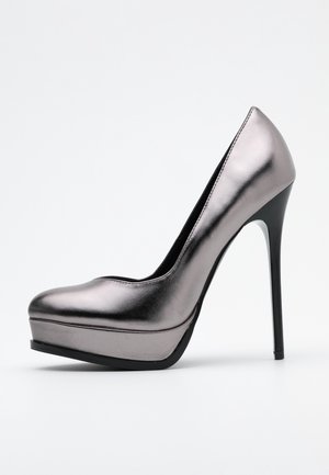 Metallisch silberner Pumps mit hohem Absatz, rundem Zehenbereich, Plateau vorne, schlanker Silhouette und Stiletto-Absatz. Glatte Textur, minimalistische Details.