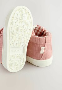 Rosa Cord-Waren High-Top-Schuhe mit weißen Gummisohlen. Das Innere zeigt ein rot-weißes Karomuster. Die Sohle hat einen Bunny-Gesichtdruck.