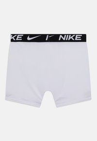 Valged sportlikud lühikesed püksid, mis on valmistatud sujuvast ja venivast kangast. Omavad musta elastset vööd, millel on valge "NIKE" logo.