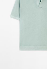 Polo tričko v mátově zelené barvě s krátkým rukávem vyrobené z texturované tkaniny. Má výstřih do V a žebrovaný lem. Jednoduchý a moderní design.