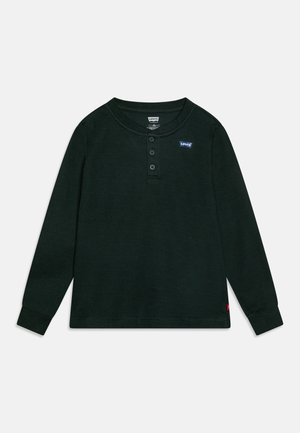 Sort langærmet Henley skjorte i vaffelstrik med tre knapper og små Levi's logo patches på brystet og nederste sidesøm.
