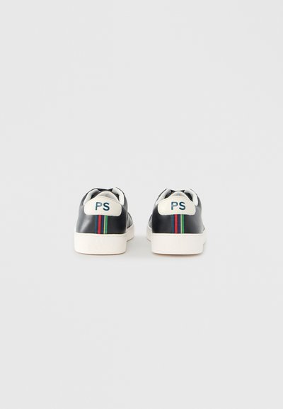 Čierne kožené tenisky s bielou podrážkou, zdobené zelenými a červenými pruhmi a logom "PS" na päte. Hladká textúra a zaoblený tvar.