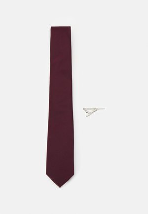 Cravatta bordeaux con una texture liscia e punta affilata, accompagnata da un fermacravatta argento caratterizzato da un design semplice ed elegante.