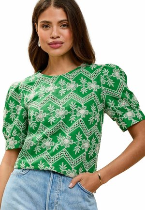 Bluză verde cu mânecă scurtă, decorată cu broderie detaliată albă în flori și zig-zag, decolteu rotund și mâneci ușor bufante.