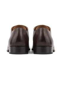Brązowe skórzane buty o gładkiej fakturze, zaokrąglonym kształcie i czarnym, niskim obcasie. Prosty design bez widocznych akcentów czy metalowych elementów.