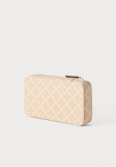 Μπεζ πορτοφόλι με φερμουάρ, με υφή προτύπου από τέμνουσες γραμμές, απαλές άκρες και ένα μικρό καφέ διακοσμητικό στο έλκτηρα του φερμουάρ.