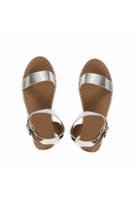 Sandalias metálicas plateadas con dos correas anchas, plantilla de cuero marrón y detalles de yute trenzado alrededor de la suela. Hebilla ajustable en el tobillo.