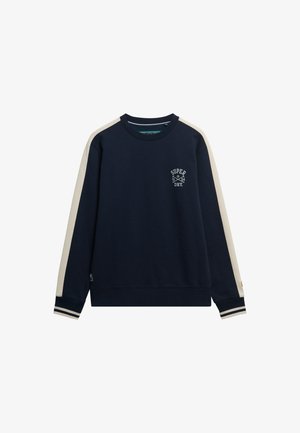 Granatowy sweatshirt z okrągłym dekoltem, kontrastowymi kremowymi paskami na ramionach, prążkowanymi mankietami i logiem "Superdry" na klatce piersiowej. Wykonany z miękkiej mieszanki bawełny.