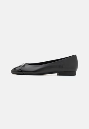 Chaussure plate noire avec un bout arrondi, fabriquée en cuir lisse et avec des accents en cuir verni au niveau du bout, présentant un ornement décoratif.