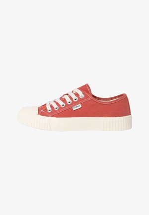 Zapatilla de lona en rojo con puntera y suela de goma blanca. Presenta cordones y costuras blancas, con una etiqueta de logo en el lateral. Diseño clásico.