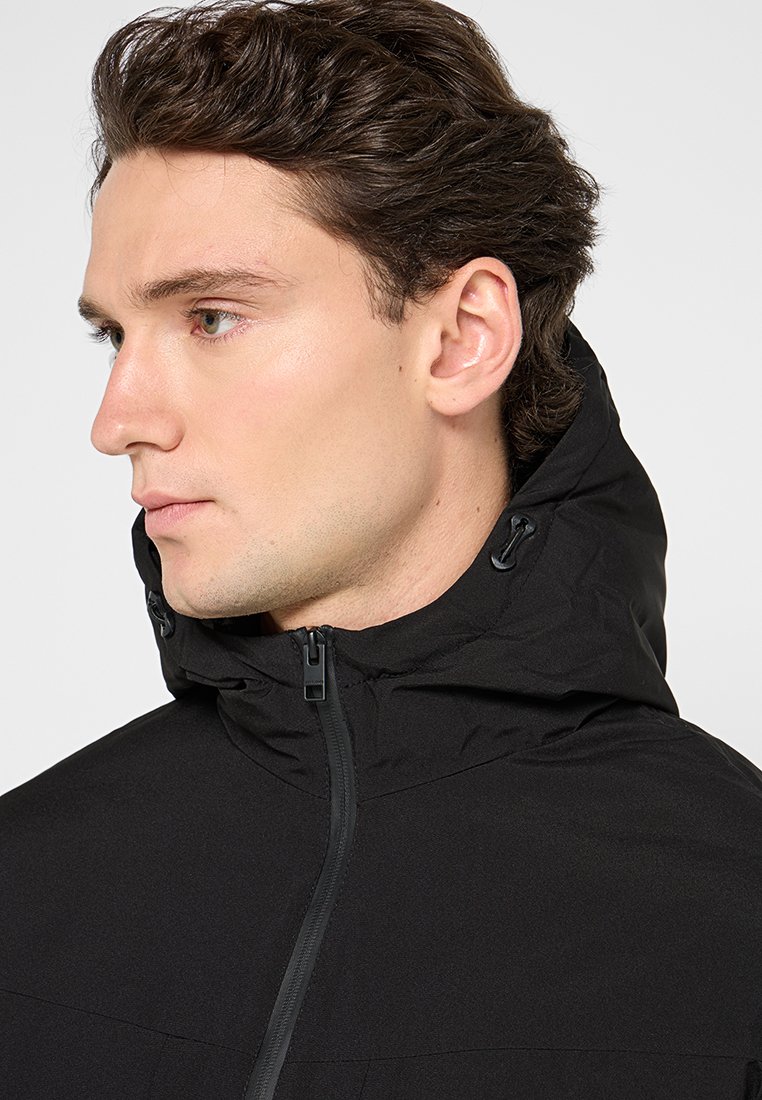 Zwarte hoodie met een voorrits, zachte textuur en verstelbare trekkoorden op de capuchon, ontworpen voor een aansluitende pasvorm.