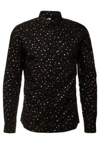 Camisa negra abotonada con mangas largas, con un patrón de lentejuelas doradas y pequeños acentos circulares negros. Tela texturizada, diseño ajustado.